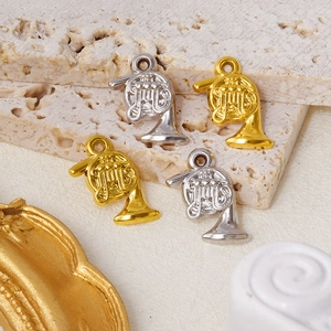 Macro detail of four French horn pendants in gold and silver finish on stone