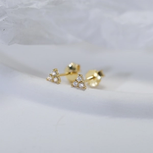Macro view of gold 925 silver stud earrings featuring three inlaid zircon stones