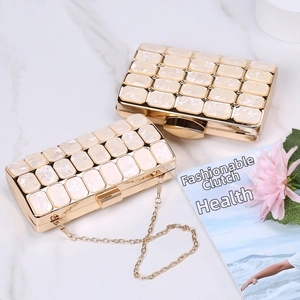 Close-up of pearl marble acrylic evening clutch with gold metal frame and chain
