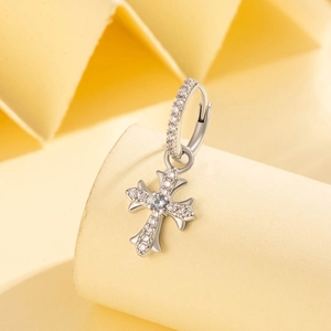 Silver vintage cross hoop earrings with sparkling cubic zirconia on a warm background