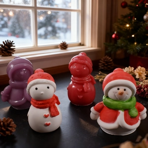 Set di quattro candele a forma di pupazzo di neve con sciarpe e cappelli sul davanzale
