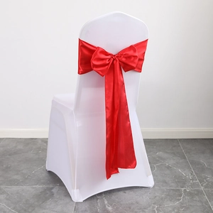White stretch chair cover with a red satin sash tied in a bow for wedding banquet