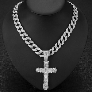 Macro detail of silver hip hop cross pendant with sparkling rhinestones on cuban chain