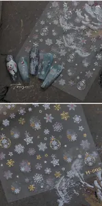 Detail of embossed snowflake nail stickers in gold and silver with metallic finish
