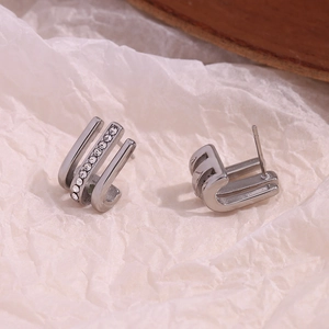 Close-up of triple-row silver J-hook earrings with sparkling clear zircon inlay