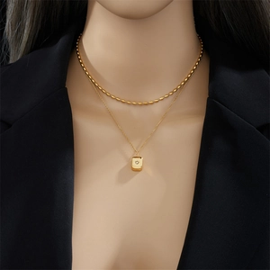 Double-layered gold titanium necklace with a rectangular diamond pendant on a model