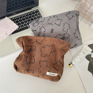 Detail of printed corduroy makeup bags with cute bear pattern and text embroidery