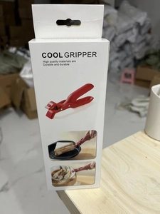 Detail of red Cool Gripper anti-scald kitchen clamp in English branded retail packaging