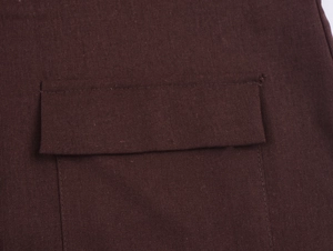 Detail shot of flap pocket design and durable maroon textured fabric on blazer