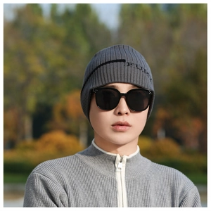 Detaillierte Textur der dunkelgrauen Strickmütze mit FURY-Stickerei und stilvoller Sonnenbrille