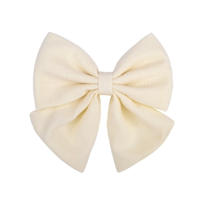 Detailed close-up of cream-colored satin bow hair clip showing elegant fabric texture