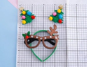 Détail d'un serre-tête de Noël avec bois de renne à paillettes et petits sapins