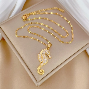 Detailed macro view of a gold seahorse pendant necklace with sparkling crystal inlay