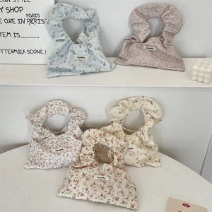 Close-up of assorted floral cotton handbags with pleated handles in five colors