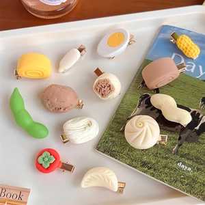 Flat lay detail of cute 3D resin food hair clips featuring dumplings and eggs in a tray