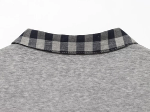 Detail of grey knit top with black and grey plaid pattern collar and fine stitching