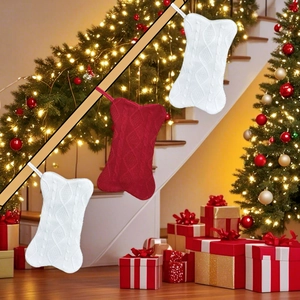Three knitted bone-shaped Christmas stockings in red and white hanging for holiday decor