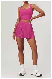 Detail shot of high-waist pleated tennis skirt and fuchsia square-neck gym crop top