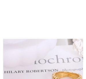 Close-up of golden titanium steel ring with textured surface on a white background