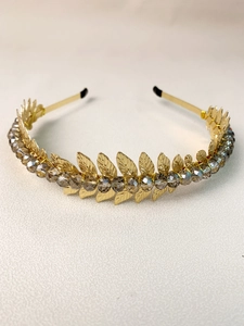 Detail of golden metal leaf headband featuring grey crystal beads and polished finish