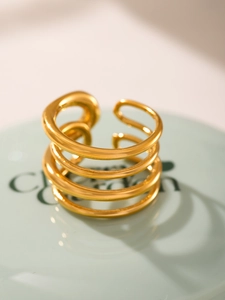 Macro shot of gold-plated multi-layer spiral ring on light green stand detail