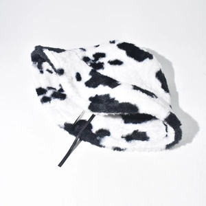 Close-up of thick soft plush material with black and white cow print on bucket hat