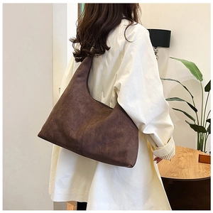 Brown frosted leather hobo bag showing capacity and drape on female model shoulder