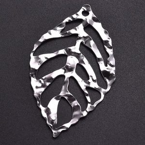 Macro shot of silver 304 stainless steel leaf pendant with hammered texture and cutout design