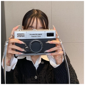 Detail of creative camera-shaped box bag in silver and black PU leather with strap