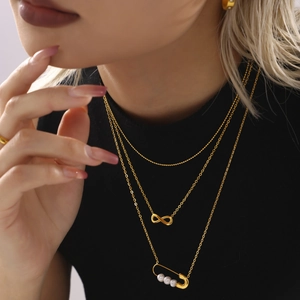 Collier à trois rangs en acier doré avec pendentif infini et épingle à nourrice perle