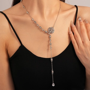 Detail of Y-shaped silver tassel necklace with rose pendant and water drop crystal on model