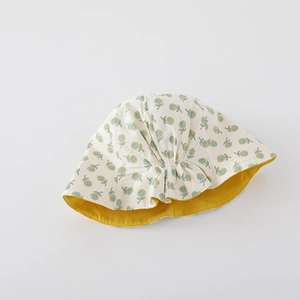 Close-up of cotton sun hat for babies featuring yellow floral print and a reversible yellow brim