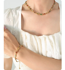 Close-up of elegant gold necklace and bracelet set with colorful zircon stones on model
