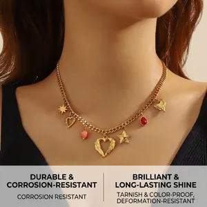 Macro detail of gold-plated chain necklace featuring heart and red drop charms