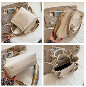 Detailansicht der cremefarbenen Beuteltasche mit braunen Griffen und Blumenanhänger