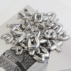 Macro shot of polished silver bubble letters pendants with glossy 3D balloon finish