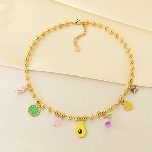 Détail du collier de perles dorées avec charms colorés en forme de fruits et fleurs