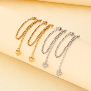 Detailed view of long tassel heart earrings in 18K gold and silver polished finishes