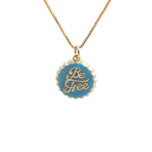 18K gold plated necklace with blue enamel 'Be Free' bottle cap pendant on white background