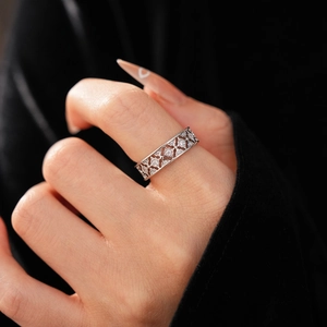 Close-up of silver hollow geometric clover ring with zircons worn on a model's finger