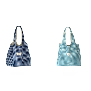 Detail of blue and green plaid woven tote bags with durable coated fabric texture