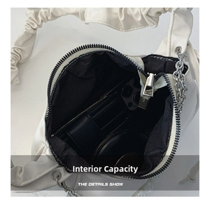 Detailed interior view of white pleated cloud bag showing storage for phone and wallet