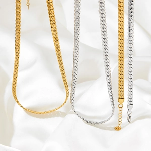 Flat herringbone snake chain necklace set in gold and silver on white silk