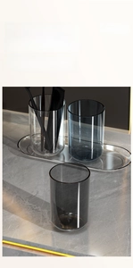 Close-up of three smokey grey transparent wash cups on matching oval storage tray