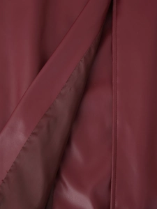 Gros plan détaillé de la texture du cuir rouge foncé et des coutures de la veste moto