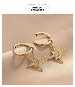 Detailed macro of gold-plated starburst hoop earrings with sparkling zircon on satin silk