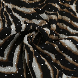 Close-up of leopard print mesh fabric with sparkling silver rhinestones and texture