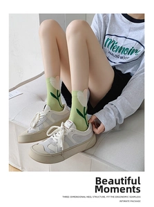 Detail view of light green cotton crew socks with 3D tulip embroidery and 3D heel design
