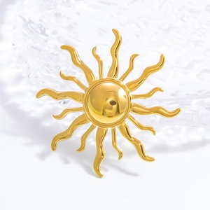 Artistic 18k gold plated stainless steel sun brooch with polished rays on white background