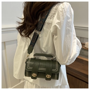 Detail of dark green PU leather Boston bag with ethnic embroidered wide shoulder strap